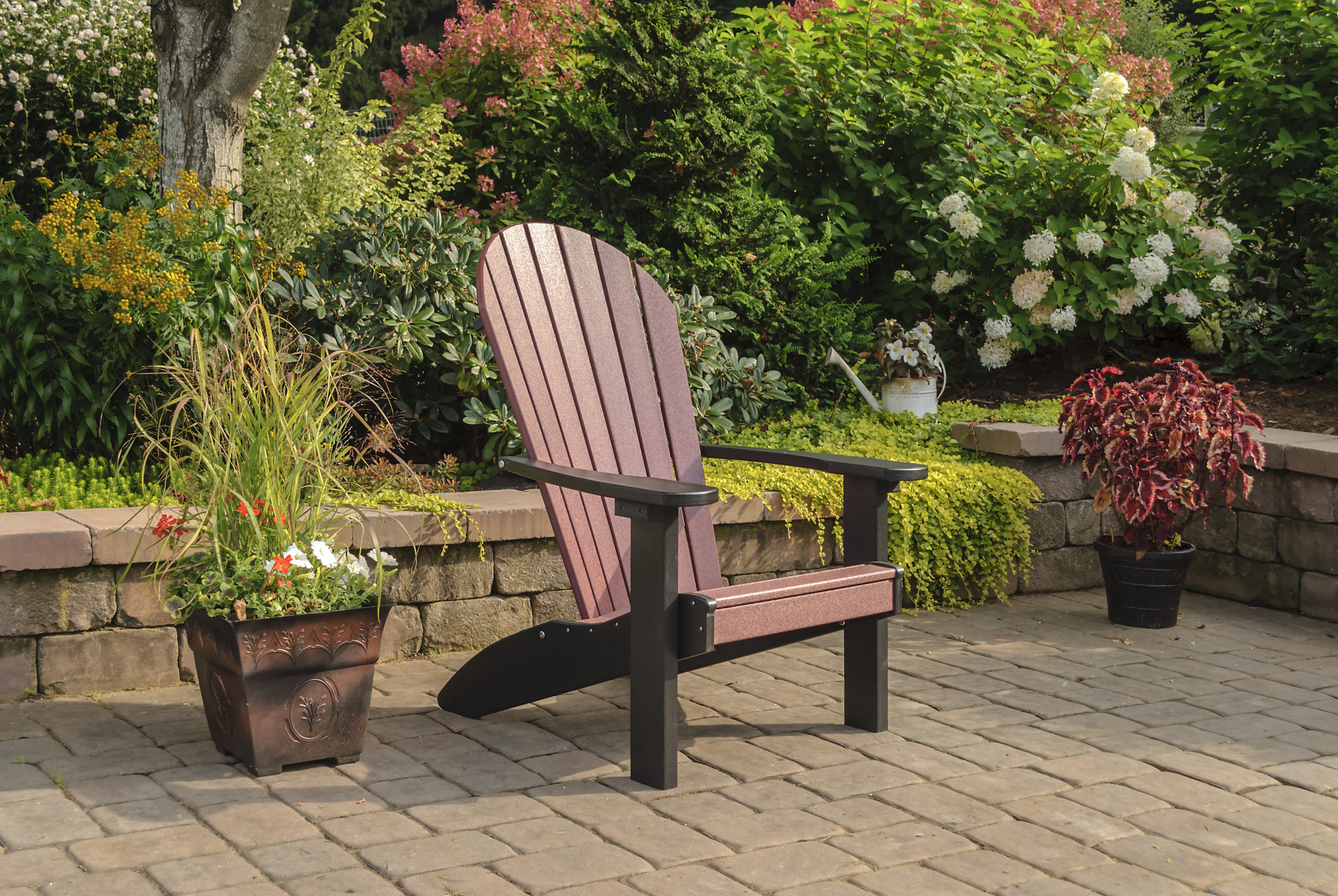 Backyard patio and maroon & black poly Adirondack chair.