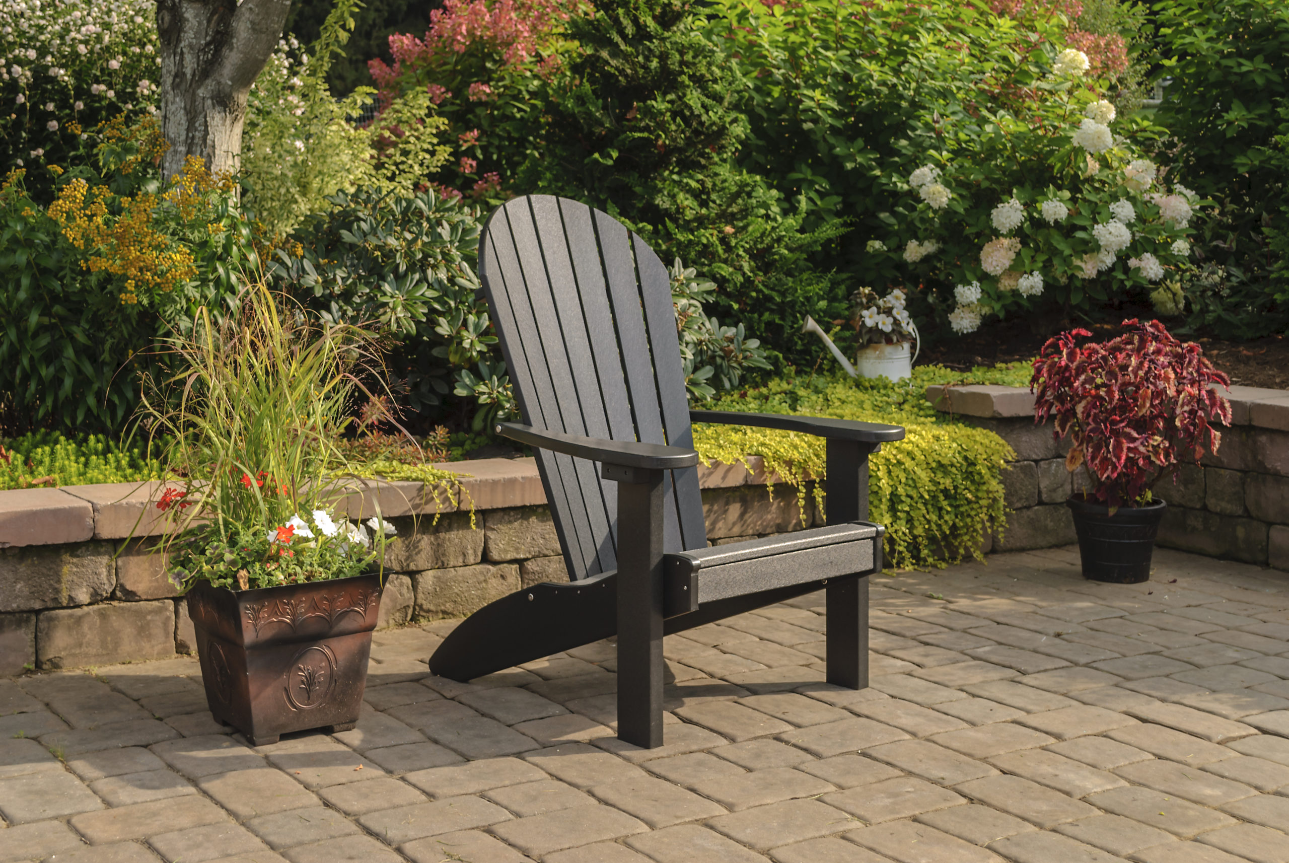 Backyard patio with black poly Adirondack chair.