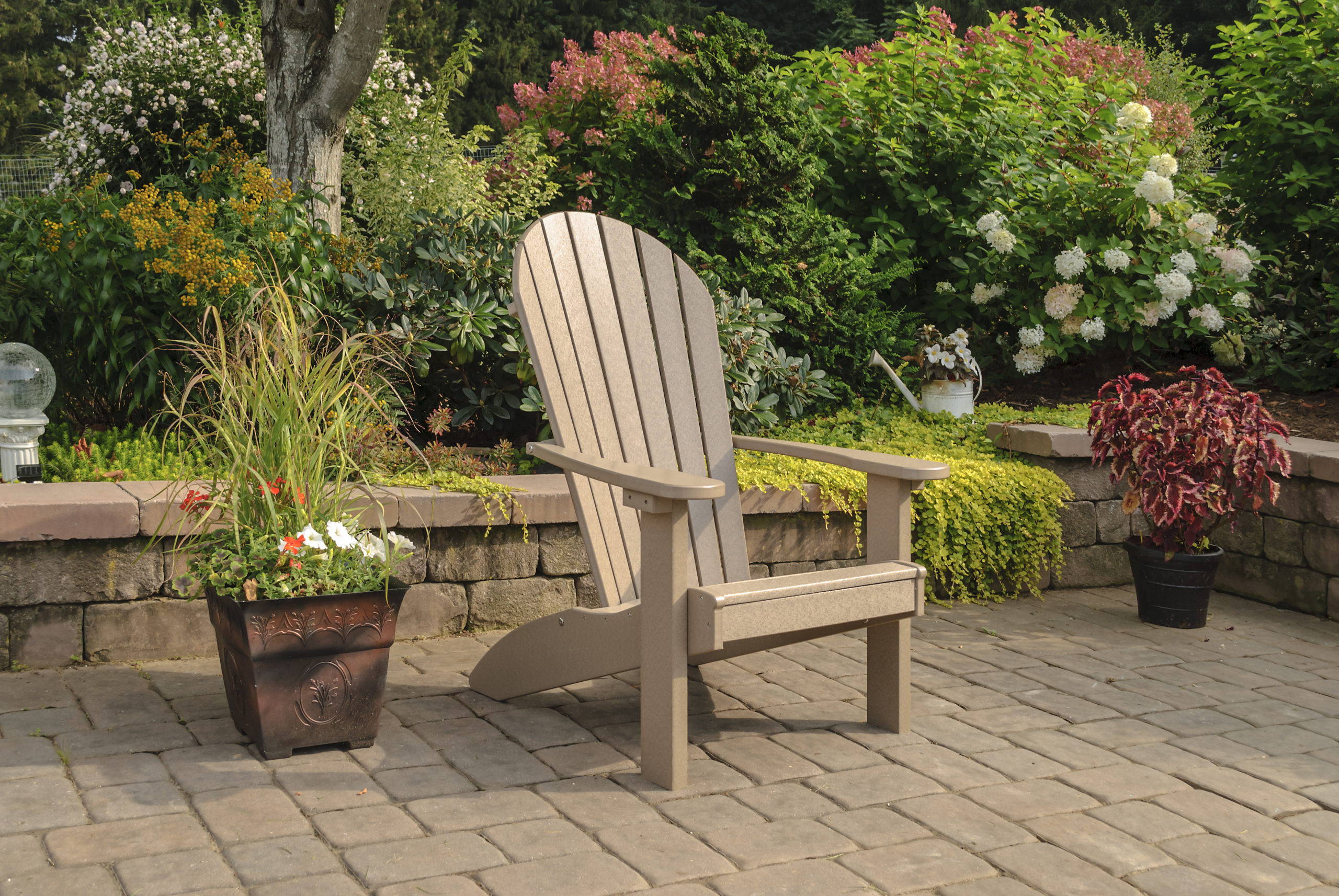 Backyard patio with tan poly Adirondack chair.