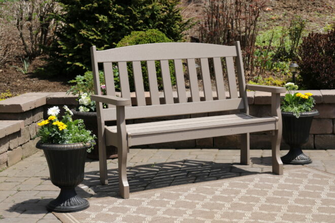 Poly garden bench displayed on a stone patio.