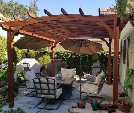 Wooden pergola shading an outdoor seating area.