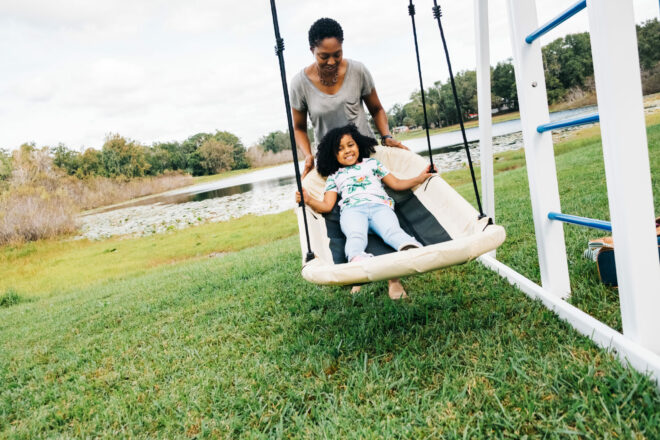 Child being pushed on a swing.