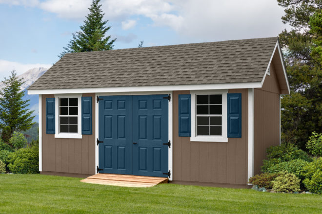 10 by 18 weathered wood shed with blue doors.