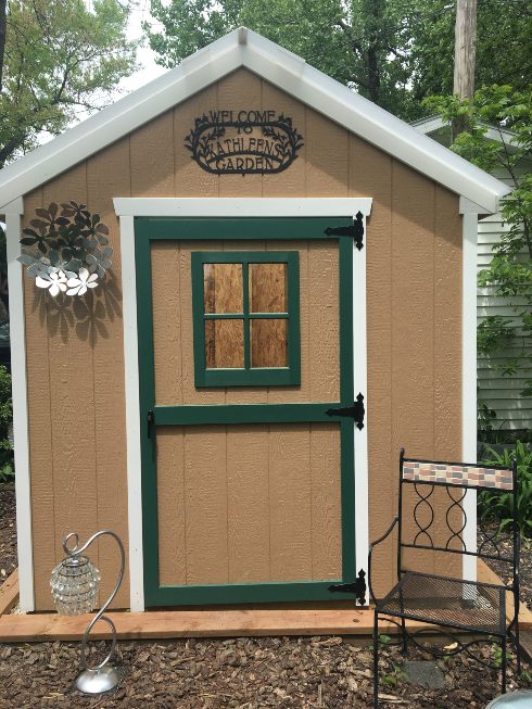 brown garden shed with green door trim